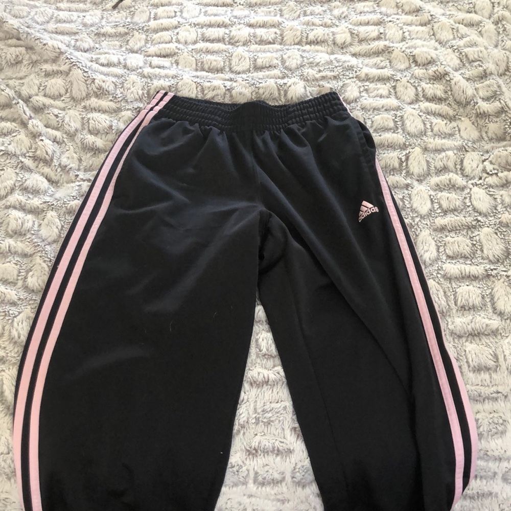 black adidas pants with pink sides and sign